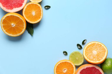 Farklı kesilmiş turunçgiller ve mavi arka planda yapraklar