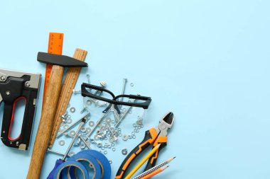 Marangoz aletleri, koruyucu gözlükler ve mavi arka planda fındıklar.