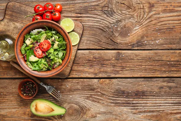 Çeri domatesli avokado salatası ve ahşap arka planda limon.
