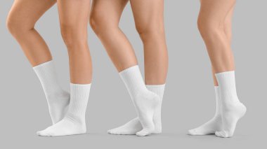Gri arka planda şık beyaz çoraplı genç kadınların bacakları