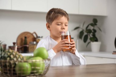 Evde elma suyu içen tatlı bir çocuk.