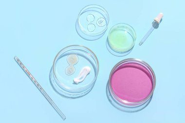 Mavi arka planda numune ve pipet bulunan petri kapları