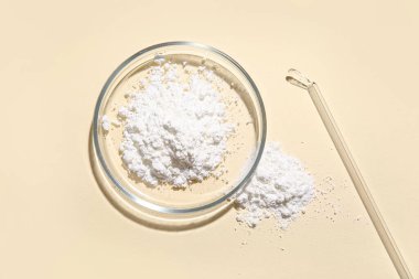 Sarı arka planda toz örneği olan petri kabı