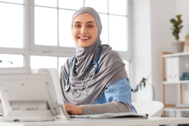 Hastanede dizüstü bilgisayarla çalışan tesettürlü kadın Müslüman doktor