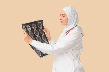 Bej arkaplanda MRI taraması yapan tesettürlü kadın Müslüman doktor