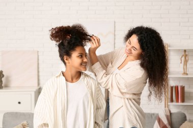 Mutlu Afro-Amerikan anne ve evde sağlıklı kıvırcık saçlı tatlı kızı