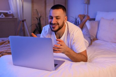 Genç adam şarap içiyor ve akşam kız arkadaşıyla görüntülü sohbet ediyor. Online randevu