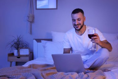 Genç adam şarap içiyor ve akşam kız arkadaşıyla görüntülü sohbet ediyor. Online randevu