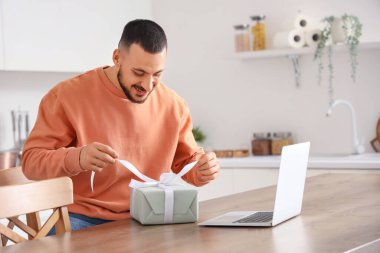 Hediye videosu olan genç bir adam evde sohbet ediyor. Online randevu