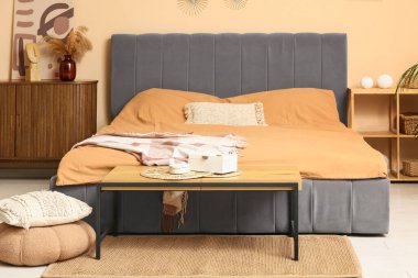 Yatak odası, yumuşak yatak ve ahşap masa.