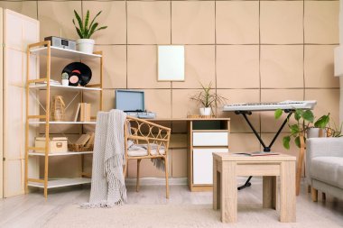 Oturma odasının içinde sentezleyici, masa ve raf ünitesi