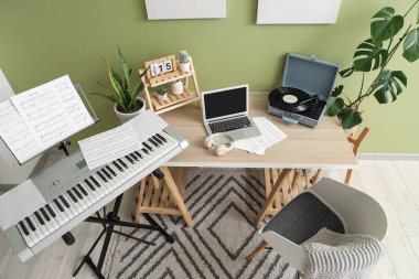 Müzisyen işyeri, kayıt cihazı ve sentezleyicisi olan bir oda.