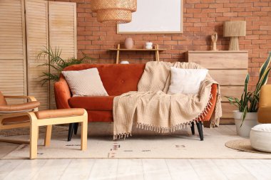 Oturma odasının içinde yastıklı ve ekoseli rahat bir kanepe.