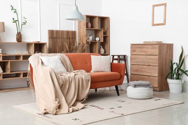 Oturma odasının içinde yastıklı ve ekoseli rahat bir kanepe.