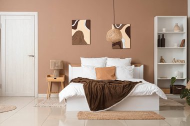 Konforlu yatak, komodin ve yatak odasının içindeki raf.