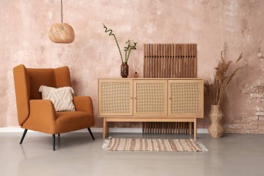 Koltuk, büfe, ekran ve vazodaki otlar oturma odasının içinde.