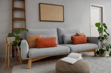 Gri kanepe, merdiven ve boş çerçeveli oturma odasının içi.