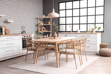 Modern mutfak, yemek masası, tezgah ve raf ünitesi.
