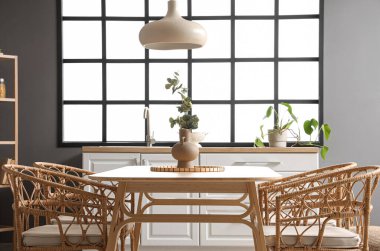 Modern mutfakta yemek masasında okaliptüs dalları olan vazo.