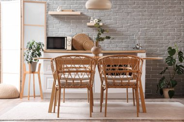 Modern mutfak, yemek masası, tezgahlar ve katlanır ekran.