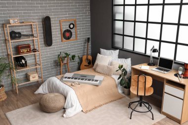 Yatak odasının içinde müzik aletleri ve işyeri var.