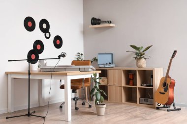 Çalışma yeri, raf ünitesi ve müzik aletleri olan bir stüdyo.