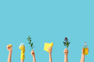 Mavi arka planda deterjan, bez ve bitki dalları olan birçok kadın eli var.