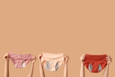 Bej arka planda farklı dönemden kalma külotlu kadın elleri