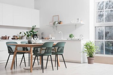 Mutfağın içinde yemek masası, tezgah ve bitkiler var.