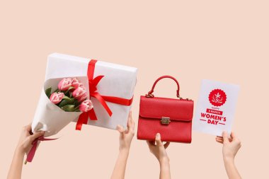 Hediye kutusu, kartpostal ve bej arka planda çiçekler olan el çantalı bir kadın. Uluslararası Kadınlar Günü için Alışveriş