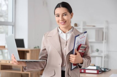 Dizüstü bilgisayarı olan genç bir iş kadını.