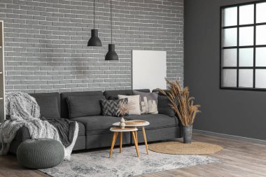 Oturma odasının içinde büyük bir kanepe, puf ve kahve masası.