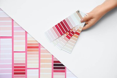 Açık arkaplanda farklı renk paletleri olan kadın eli