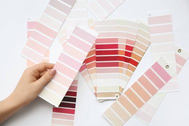 Açık arkaplanda farklı renk paletleri olan kadın eli