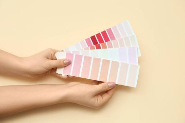 Renk arkaplanında farklı renk paletleri olan kadın elleri, yakın plan