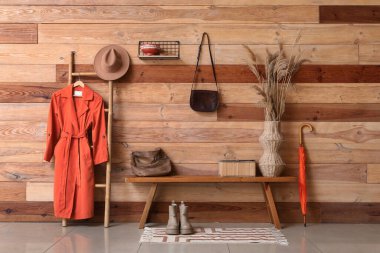 Çantalı bank, vazodaki otlar ve koridordaki merdivende asılı duran palto.