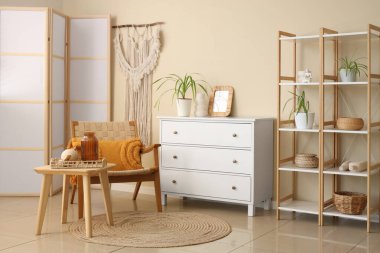 Oturma odasının içinde koltuk, çekmece ve raf ünitesi var.