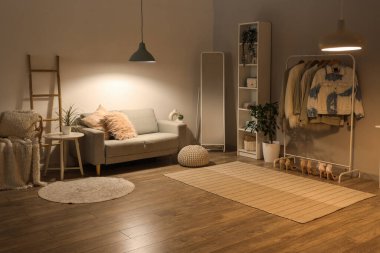 Parlayan lambalar, kanepe ve akşamları giysi rafı olan salonun içinde.