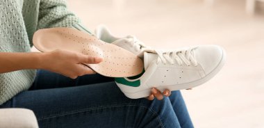 Kadın ayakkabısına ortopedik taban takıyor.