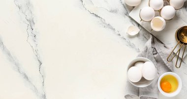 Beyaz zemin üzerinde çiğ tavuk yumurtası ve metin için yeri olan tutucu ve kase