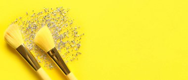 Makyaj fırçaları ve simler sarı arkaplanda metin için boşluk ile