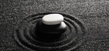 Japon kaya bahçesinde çizgileri olan siyah kumdaki taşlar. Zen kavramı