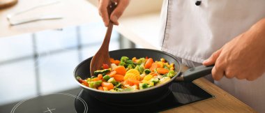 Mutfakta spatula kızartan erkek aşçı, yakın plan.