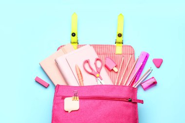 Mavi arka planda kırtasiyeli pembe okul çantası.