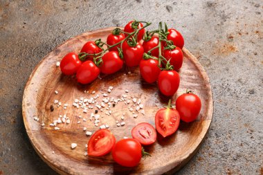 Koyu arkaplanda taze kiraz domatesli ahşap tabak.