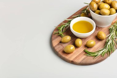 Olgun zeytinli kaseler ve gri arka planda yağ