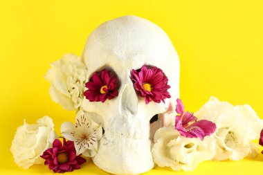 Sarı arka planda güzel çiçekli insan kafatası, yakın plan.