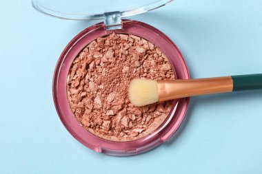 Mavi arkaplanda makyaj fırçası ve fosforlu kalem