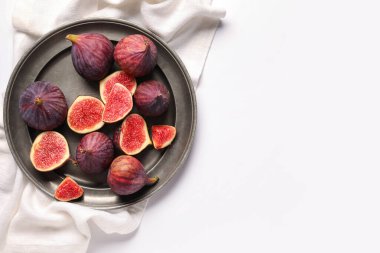 Beyaz arka planda taze, sulu incirli bir tabak.