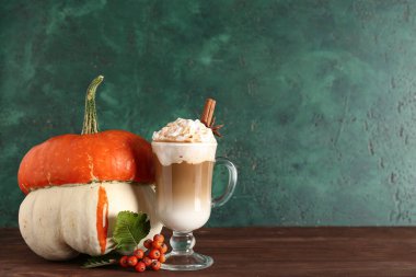 Cam bardak, tarçınlı balkabaklı latte ve ahşap masada yıldız anason.